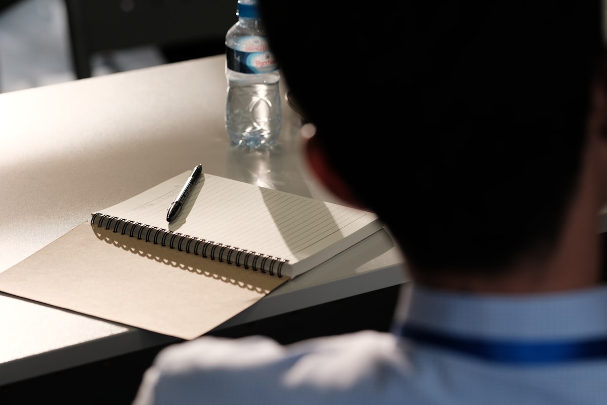 Notebook and pen on an exam desk — RRB NTPC Graduate CBT preparation